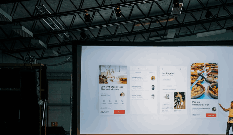 Live feed: a presenter on stage in front of a large projection screen